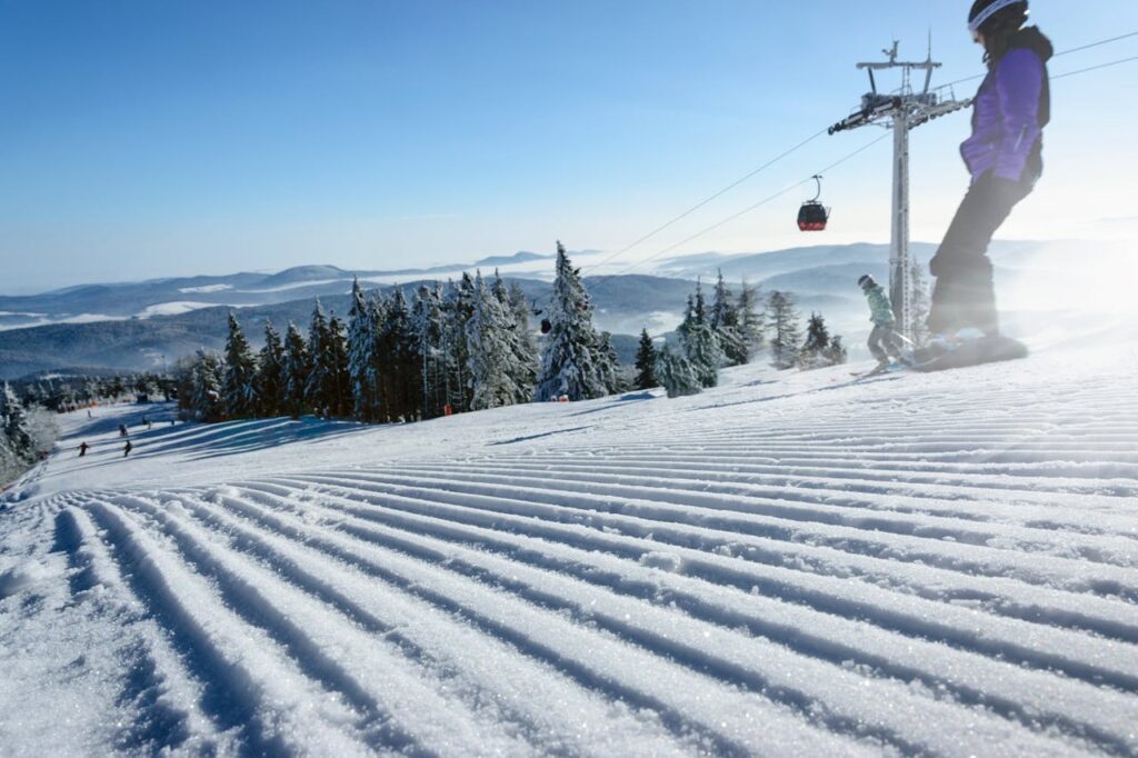 photography-of-person-ice-skating-880497 Winter scene of skiers on a snowy slope with cable car and clear sky