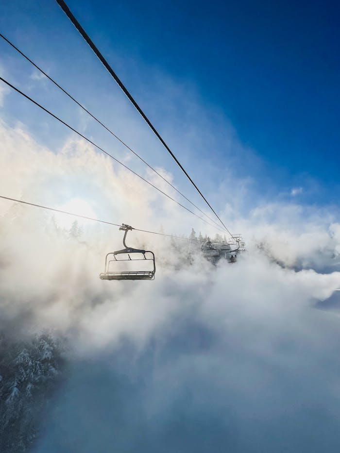A ski lift rises through fog and clouds in Stratton, Vermont, offering a breathtaking view.